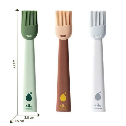 Three silicone basting brushes with different colored handles on a white background.