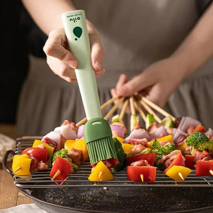 Person using a green brush to apply oil on skewered vegetables and meat on a grill.