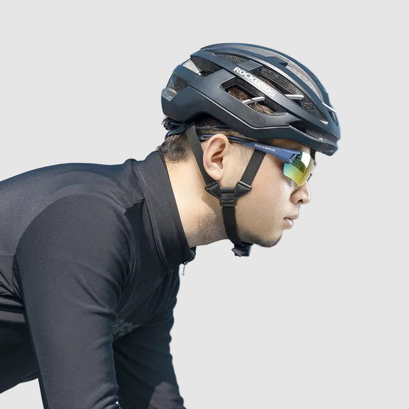 Person wearing a black helmet and sunglasses on a clear day