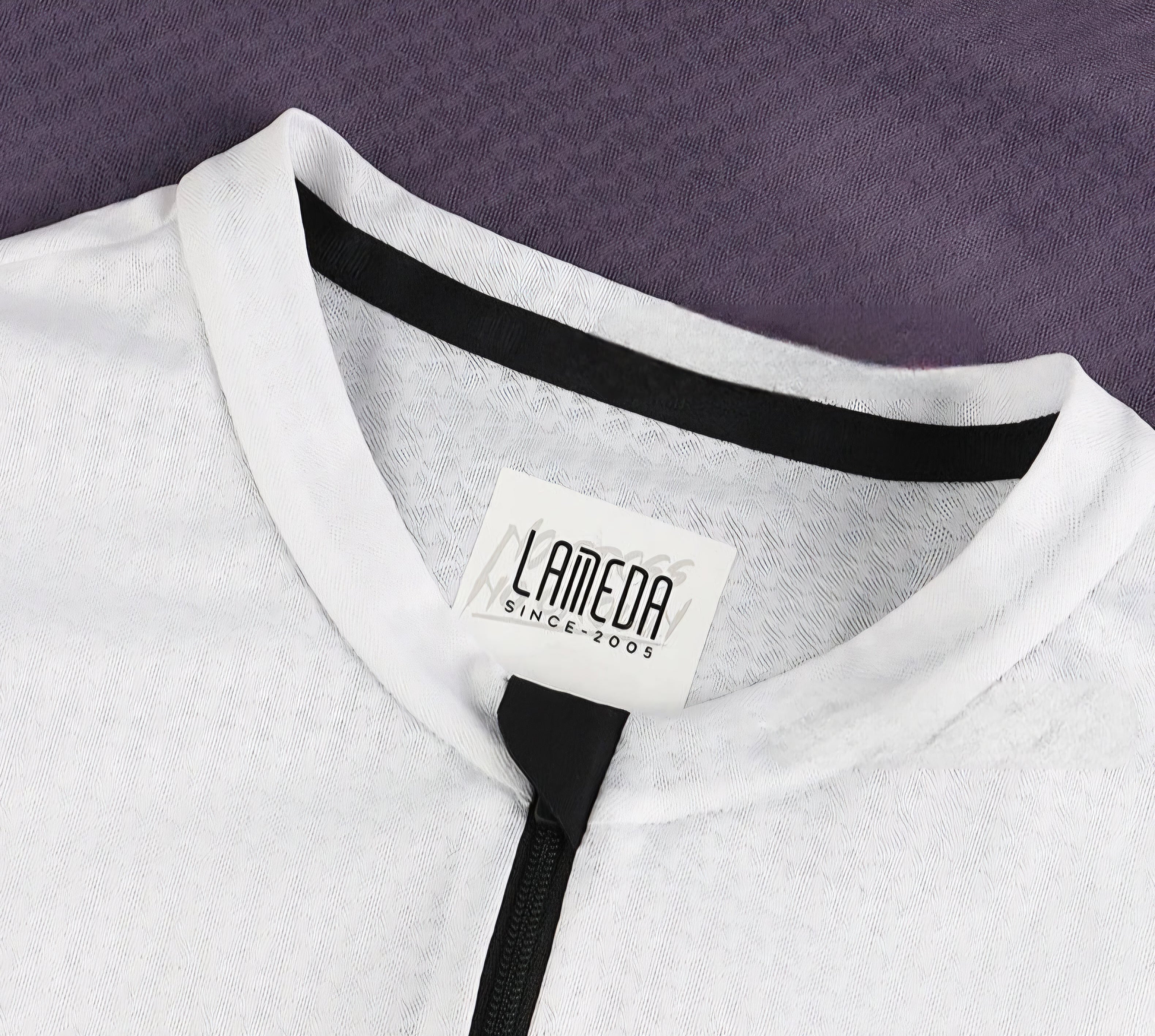 Close-up of a white garment with a Lameda label on a purple background