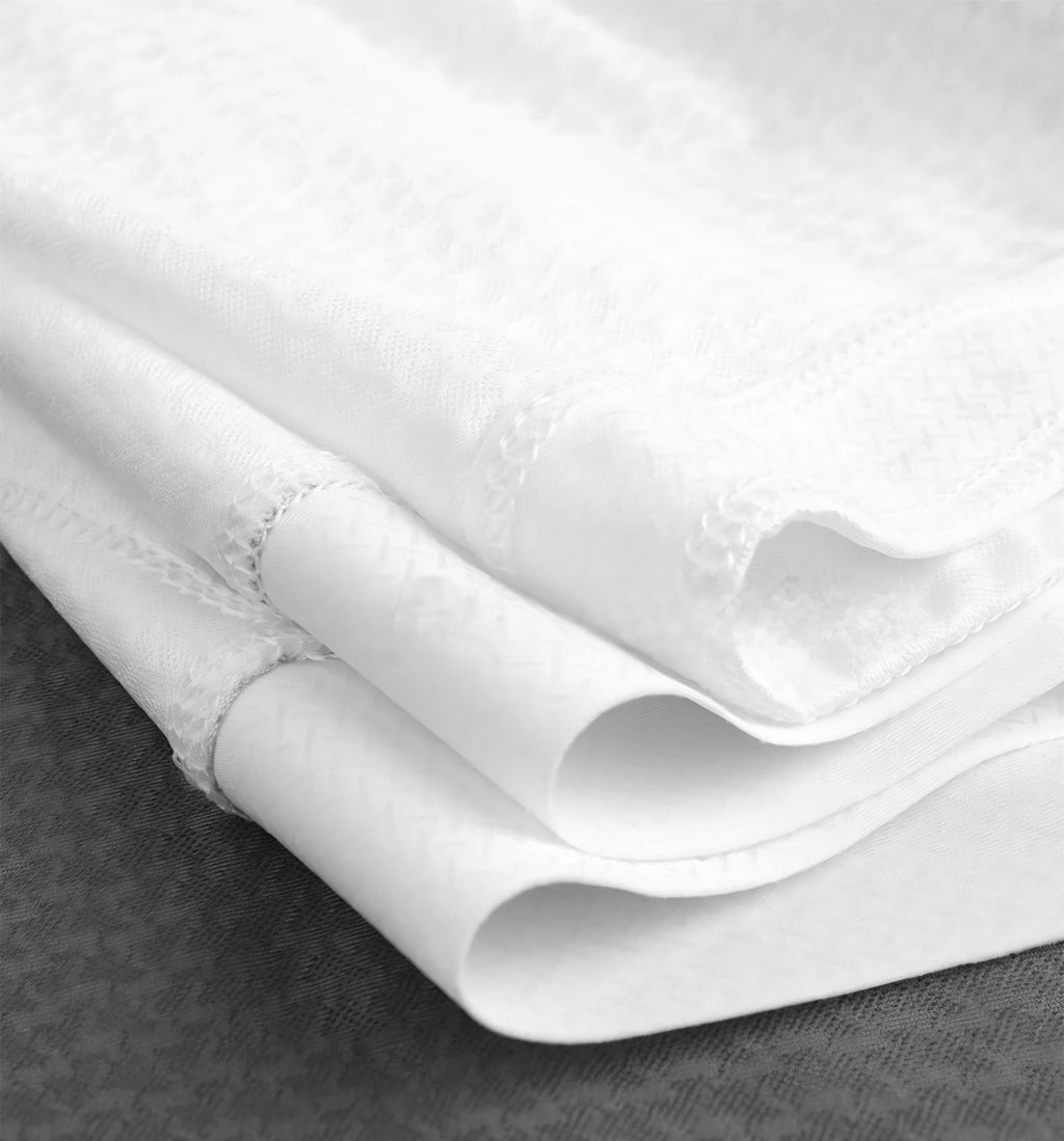Close-up of white fabric with a textured pattern on a dark surface